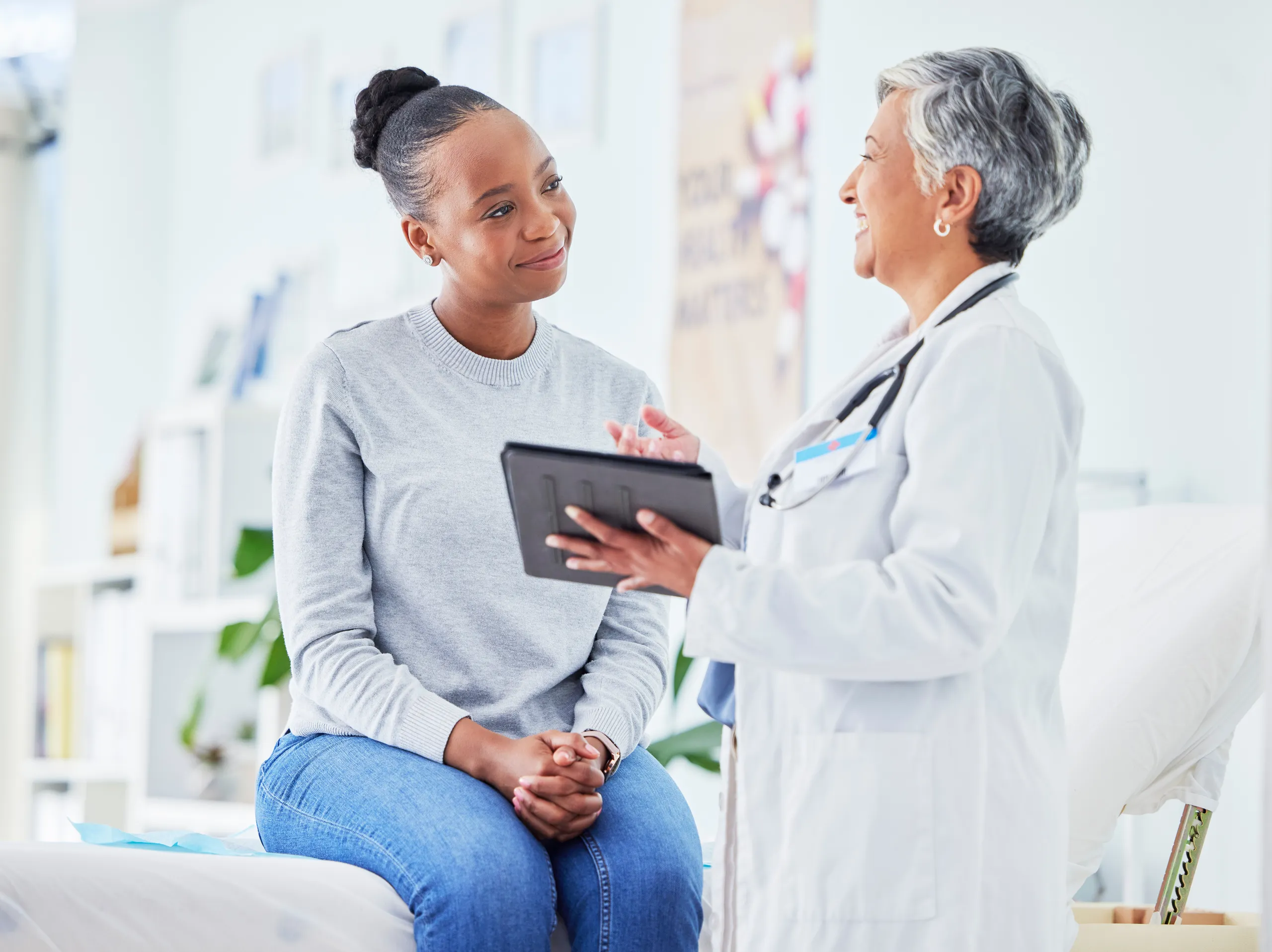 A physician discussing care with a patient using a digital tablet